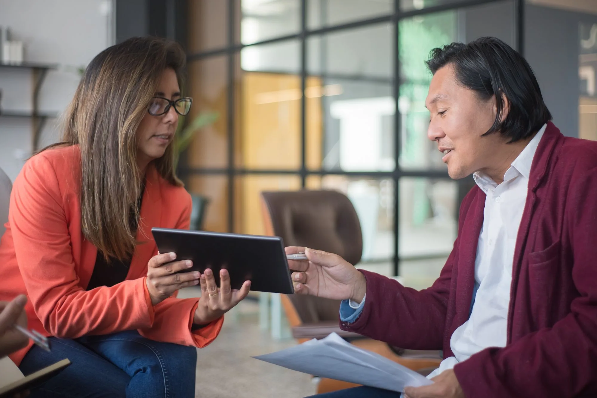 Two business professionals talking through a plan together over a tablet