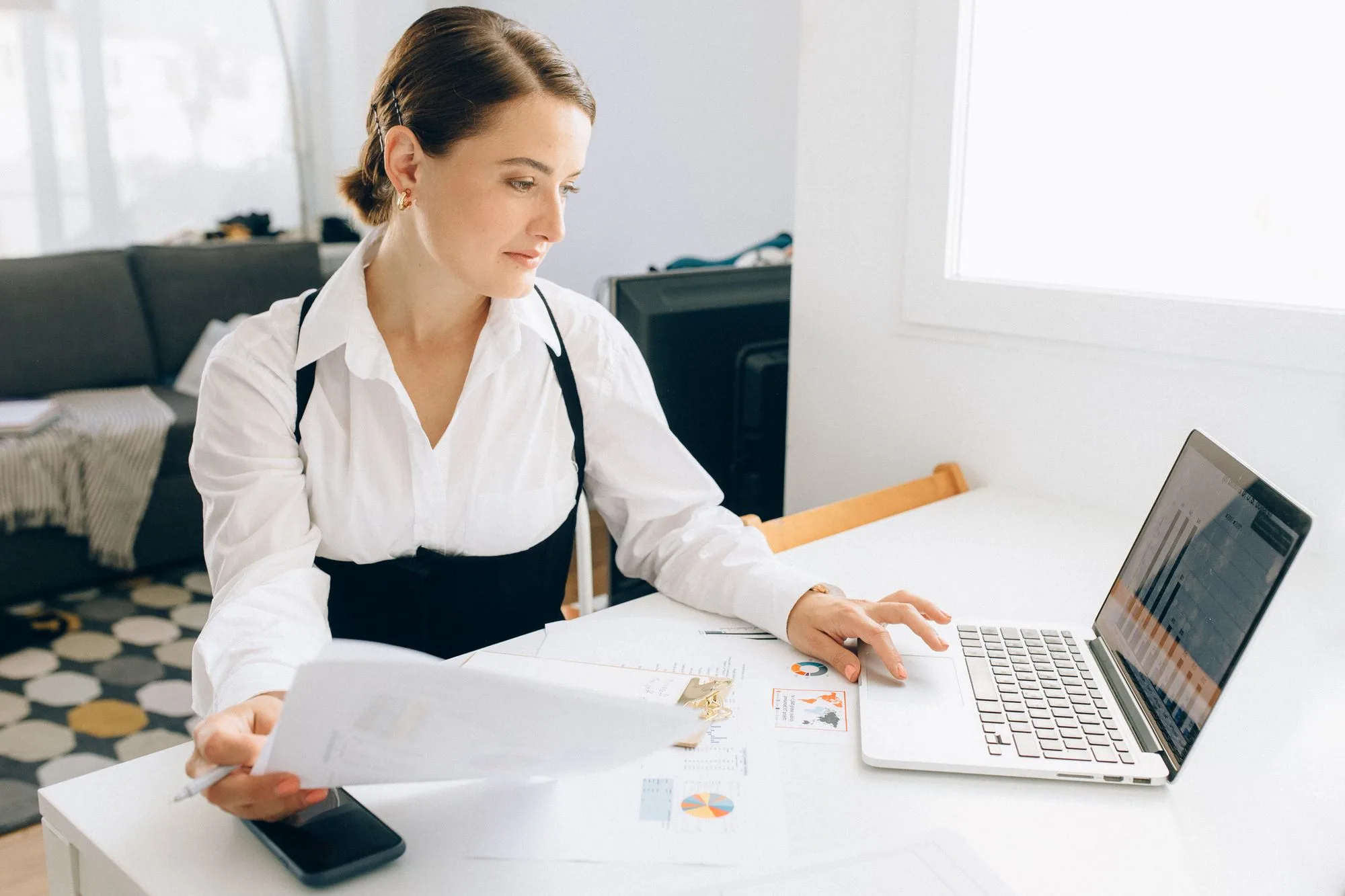 Business owner reviewing a performance report on her laptop at a desk